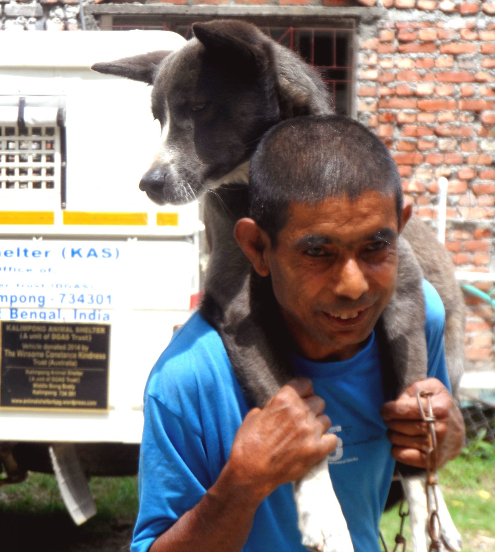 Happily carrying a dog after her health check-up is done at Village ABC camp by KAS