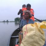 Image 8: A family stranded in a flooded village being transported to a safer location in TCF’s boat.