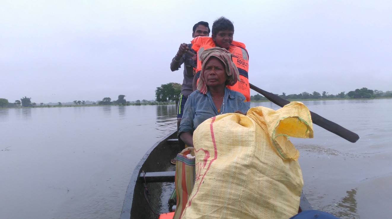 Image 8: A family stranded in a flooded village being transported to a safer location in TCF’s boat.
