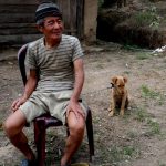 An elderly sits with his pup for its anti-rabies vaccination