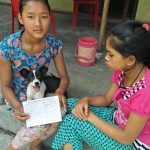 A happy young owner with a pup and its vaccine record card